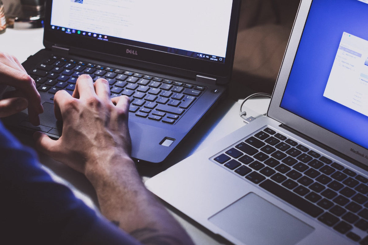Hands typing on a laptop